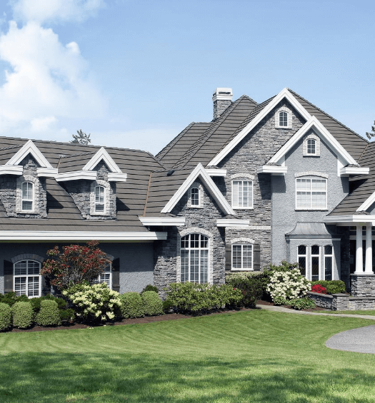 slate gray home with stone accent and big yard